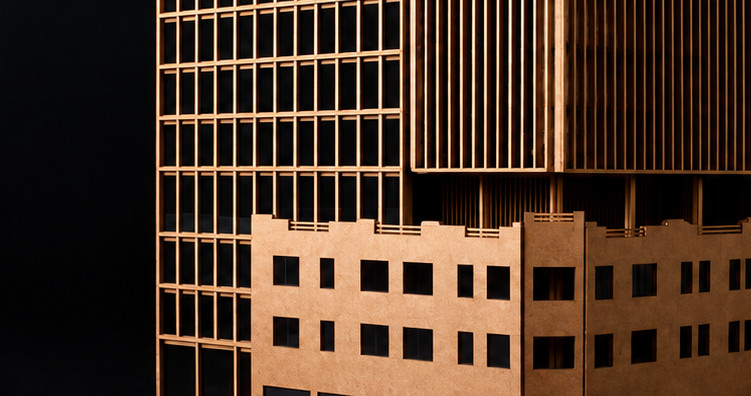 Maqueta de una torre con retícula estructural y celosías verticales de madera sobre un basamento de dos niveles, fotografiada sobre fondo oscuro.